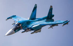 藍色軍用飛機在清澈的天空下飛行，機翼下掛載導彈 — 軍事動圖 壁紙