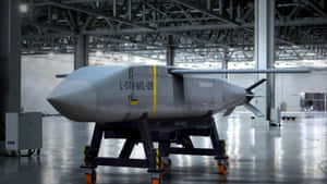 大型機庫內有輪子支架上的灰色軍用無人機，帶有鋼樑。 — 使命召喚：現代戰爭 壁紙