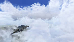 灰色戰鬥機在雲層上方飛行，下方可見山脈。 — 微軟模擬飛行 壁紙