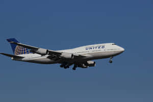 聯合航空波音747飛機在藍天中飛行，起落架放下。 — 天空景觀 壁紙
