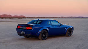 藍色Dodge Challenger肌肉車停泊在沙漠中，夕陽西下。 — 酷車 壁紙