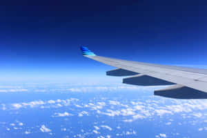 飛機機翼在明亮的藍天中翱翔於雲層之上