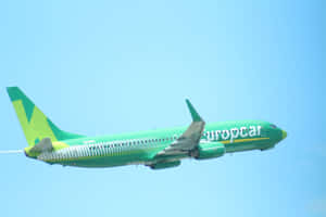綠色 Europcar 飛機在藍天飛行 — MacBook Pro M4 壁紙