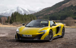 黃色McLaren跑車停泊在碎石上，靠近雪山和森林。 — MacBook Pro 13 壁紙