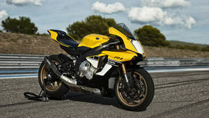 黃色Yamaha R1運動電單車喺有護欄同山丘嘅賽道上。 — 機車 壁紙
