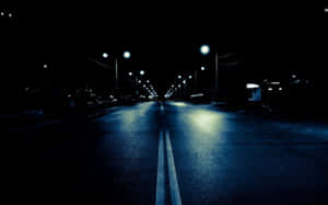 夜晚空蕩的道路，閃爍的路燈在濕漉漉的路面上反射。 — 夜景城市 壁紙