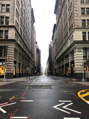 灰色天空下，空蕩的城市街道，高樓大廈和褪色的道路標記。 — 城市景觀 壁紙