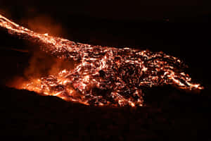 發光橙色熔岩河流與黑暗火山地形形成對比，夜晚 — MacBook Air M4 壁紙
