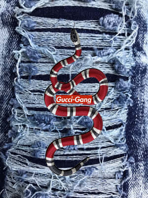 一條風格化的蛇，帶有Gucci Gang標誌，背景為破爛牛仔布。 — 老友記 壁紙