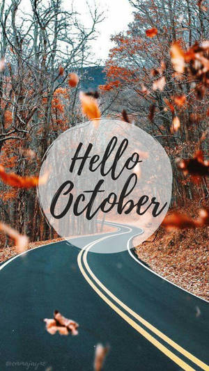 蜿蜒的道路穿過秋日樹林，飄落的樹葉和Hello October文字。 — 秋天 壁紙