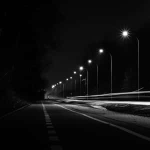 夜晚道路，有路燈和模糊的汽車運動軌跡。 — 月色夜空 壁紙