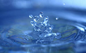 水滴冠在藍色水面上飛濺。