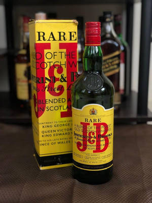 復古J&B Rare蘇格蘭威士忌瓶連原裝盒在紋理表面上。