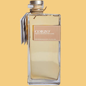一瓶透明的 Corzo Tequila Reposado 玻璃瓶，立在純黃色背景前。