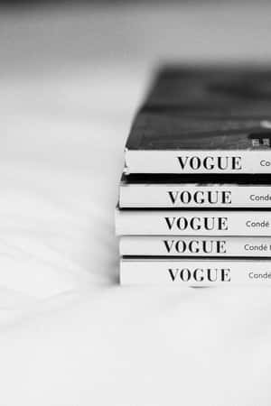 黑白背景下的一疊Vogue雜誌放在白色布料上。 — 2:3 壁紙