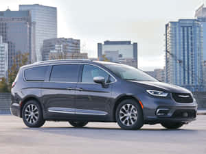 灰色Chrysler Pacifica小型貨車停泊喺城市天台，後面係城市天際線。 — 奧迪 GIF 壁紙