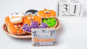 萬聖節餅乾，形狀包括南瓜、鬼魂和蝙蝠，附有'Happy Halloween'標誌和10月31日日曆。 — 萬聖節 壁紙