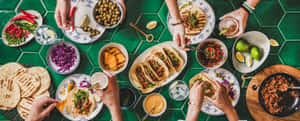 一群人在綠色瓷磚桌上進食 — 墨西哥 壁紙