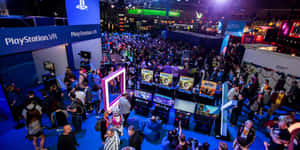 人群在PlayStation VR遊戲展覽中，有明亮的燈光和展位。 — 遊戲 壁紙