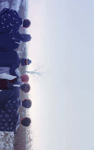 一群穿著冬季外套的人站在雪中仰望天空 — 防彈少年團 合照 壁紙
