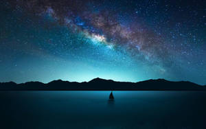 銀河星空下寧靜湖面上的帆船 — 月色夜空 壁紙