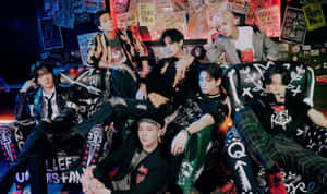 七位時尚K-pop偶像在龐克主題房間的塗鴉沙發上擺姿勢。