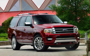 紅色福特 Expedition SUV 停泊在現代建築附近，周圍有綠化。 — 1280x800 壁紙