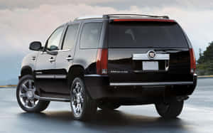 黑色Cadillac Escalade SUV停在陰天下濕漉漉的路面上。 — Steam Deck 壁紙