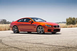 橙色BMW M6跑車停在陽光明媚的田野碎石路上。 — MacBook Air 13 壁紙