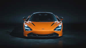 在黑暗的工作室環境中照亮的橙色McLaren跑車。 — 麥拿侖 GIF 壁紙