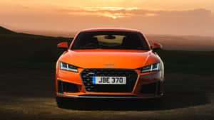 橙色奧迪TT跑車停放在日落時分的泥路上。 — Audi R8 GIF 壁紙