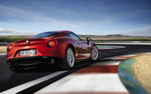 紅色Alfa Romeo 4C在賽道上奔馳，帶有動態模糊和藍天背景。 — Steam Deck 壁紙
