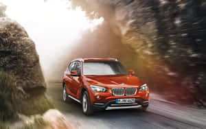 紅色BMW X1 SUV在日落時快速穿過森林。 — Steam Deck 壁紙