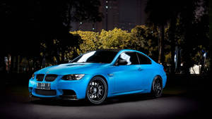 藍色BMW M3跑車夜間停放在城市環境中。 — 藍色 壁紙