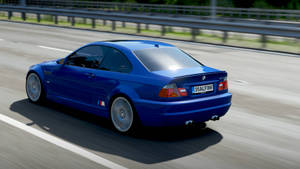 藍色BMW M3在陽光明媚的高速公路上疾馳，帶有動態模糊效果。 — 汽車 壁紙