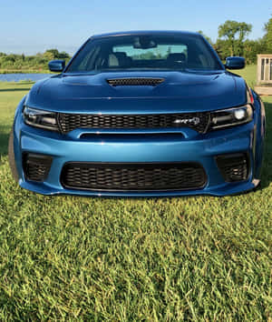 藍色Dodge Charger SRT停放在湖邊的綠色草地上。 — 小米Mix Flip 2 壁紙