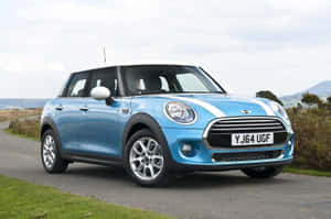 一輛藍色Mini Cooper，白色車頂，停泊在靠近山丘的鄉村道路上。 — 酷車 壁紙