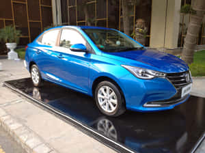 現代建築外黑色展示平台上的藍色轎車，帶有棕櫚樹。 — 唐人街 GIF 壁紙