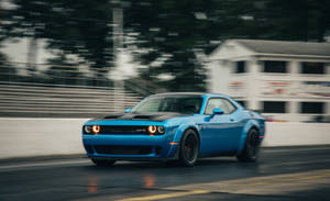 藍色肌肉車在夜間賽道上疾馳，帶有動態模糊效果。 — Dodge challenger GIF 壁紙