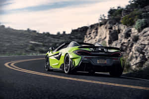 青檸綠色McLaren跑車在日落時分行駛在山路上。 — Surface Pro 壁紙
