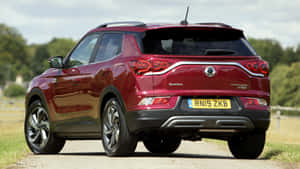 紅色SsangYong Tivoli SUV停泊在碎石路上，靠近樹木。 — 酷車 壁紙