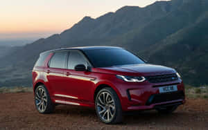 紅色 Land Rover Discovery 停泊在山間觀景點，欣賞日落。 — Steam Deck 壁紙