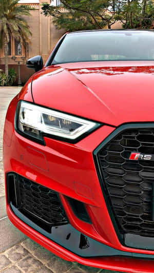 紅色Audi RS汽車停在石頭車道上，後面有棕櫚樹和建築物。 — Audi R8 GIF 壁紙
