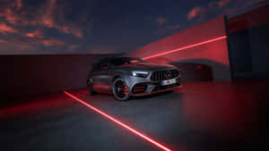 啞光灰色 Mercedes-AMG A45 S 在暮色中被紅色激光束照亮。 — 7680x4320 壁紙