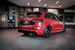 啞光紅色ABT奧迪RS3 Sportback在高級汽車展廳中，展示遊戲機和輪圈。 — Surface Pro 壁紙