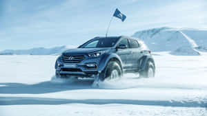 藍色現代Santa Fe SUV在雪地行駛，背景有山脈。 — 現代汽車 壁紙