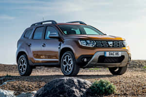 青銅色Dacia Duster SUV在晴朗的天空下，停放在岩石地形上，附近有稀疏的綠植。 — Surface Pro 壁紙