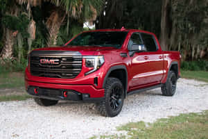 紅色GMC Sierra AT4皮卡車停在靠近長滿苔蘚樹木的碎石上。 — 林寶堅尼貨車 壁紙