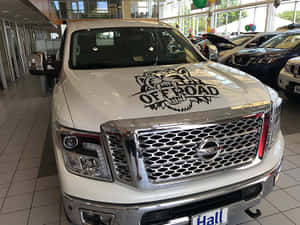 白色日產卡車在汽車經銷商展廳中帶有老虎貼紙。 — 酷車 壁紙
