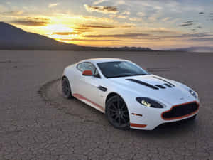 白色Aston Martin跑車停在龜裂的沙漠地面上，夕陽西下。